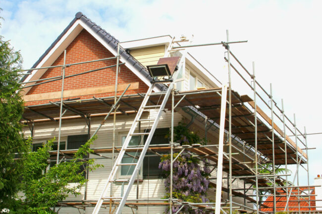 Outside renovation of modern residential house, scaffolding tower